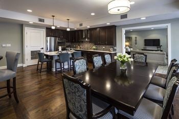 a kitchen with dark cabinets and a large table with a vase of flowers on it at Arbor Hills, Lakeland, FL, 33805